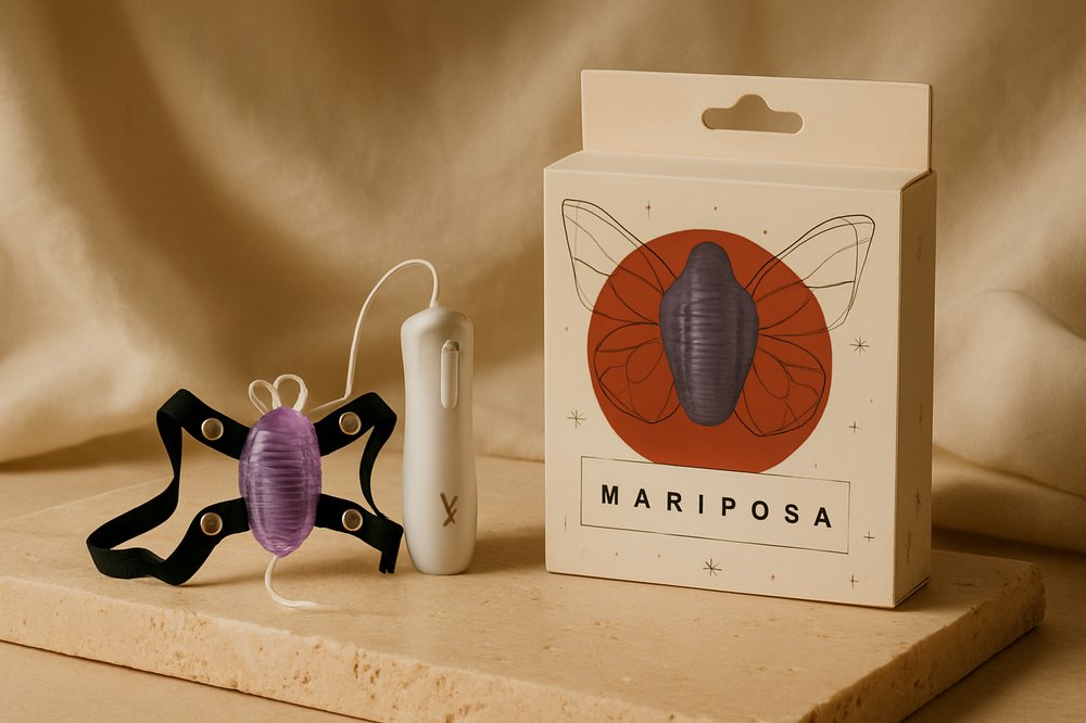 Arnés mariposa vibradora Starsex con su control y caja, sobre piedra cálida